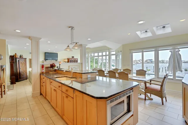 a large kitchen with kitchen island a large counter top space appliances and cabinets
