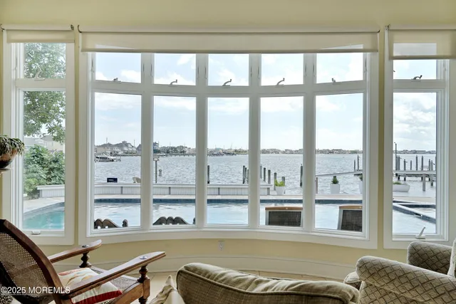 a open kitchen with granite countertop a refrigerator a stove a sink a dining table and chairs with wooden floor