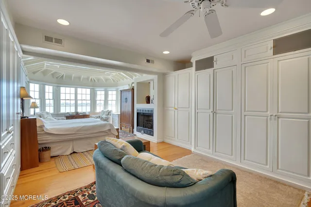 a spacious bedroom with a bed and wooden floor