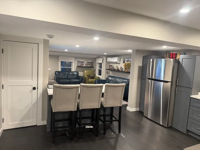 a kitchen with a dining table chairs refrigerator and cabinets
