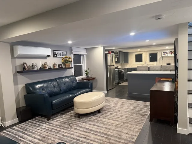 a living room with stainless steel appliances granite countertop a couch and cabinets