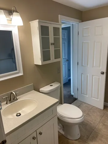 a bathroom with a toilet sink and mirror