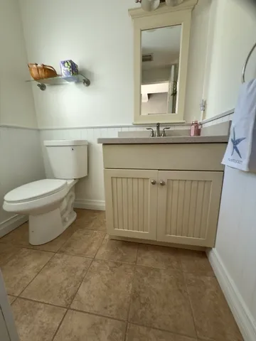 a bathroom with a granite countertop sink a toilet and mirror