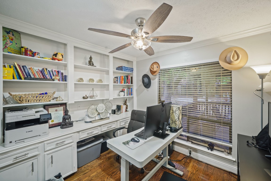 15831 Ridge Park Drive Houston, TX 77095 - Photo 11 of 26 This home office features built-in shelves, a large window with blinds, a ceiling fan, and ample desk space, creating a bright and organized work environment.