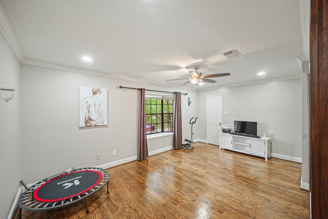 15831 Ridge Park Drive Houston, TX 77095 - Photo 13 of 26 This room features polished hardwood floors, neutral walls, and a ceiling fan. It has a large window, allowing natural light. The space is versatile, suitable for a home gym or media room.