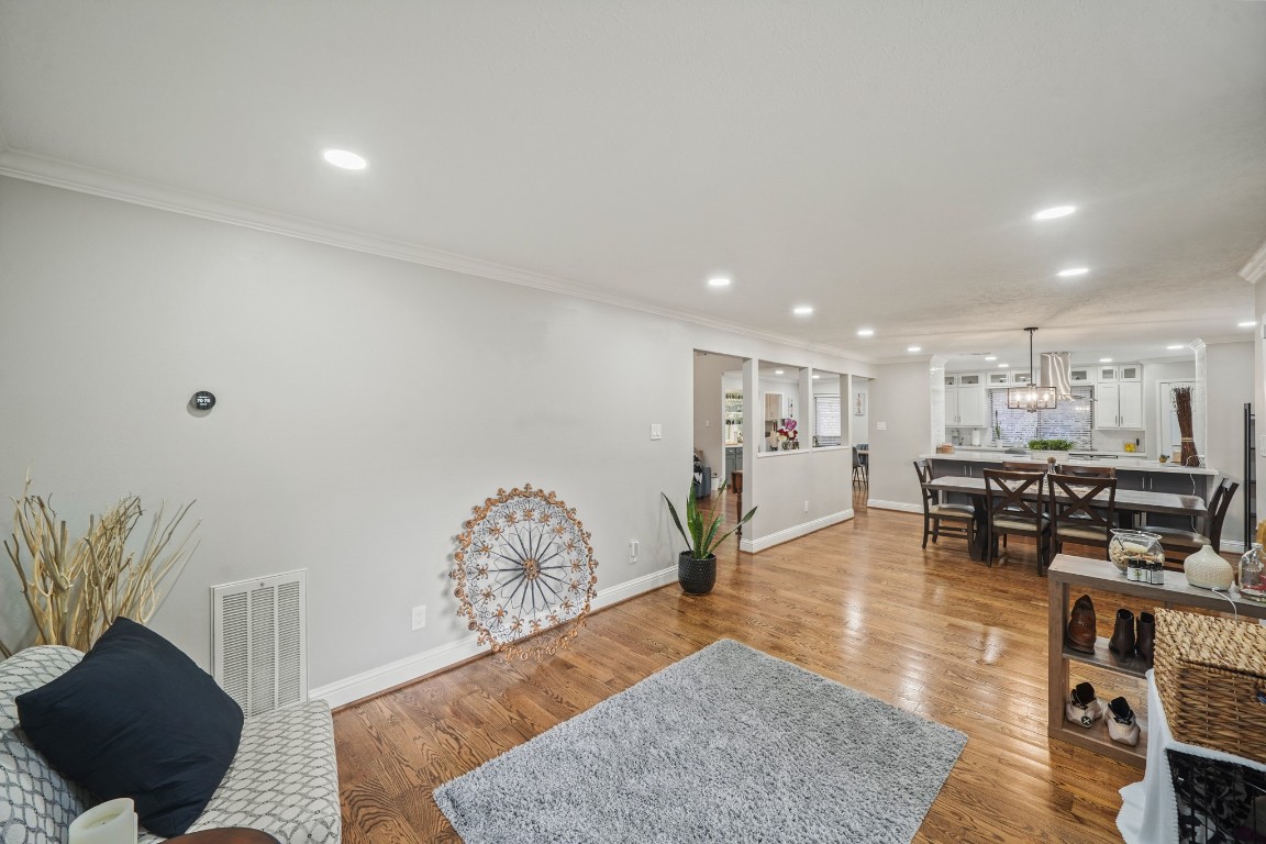 15831 Ridge Park Drive Houston, TX 77095 - Photo 15 of 26 This photo showcases an open-concept living and dining area with hardwood floors, recessed lighting, and neutral walls. The space is bright and inviting, featuring a modern dining set and a view into a contemporary kitchen.