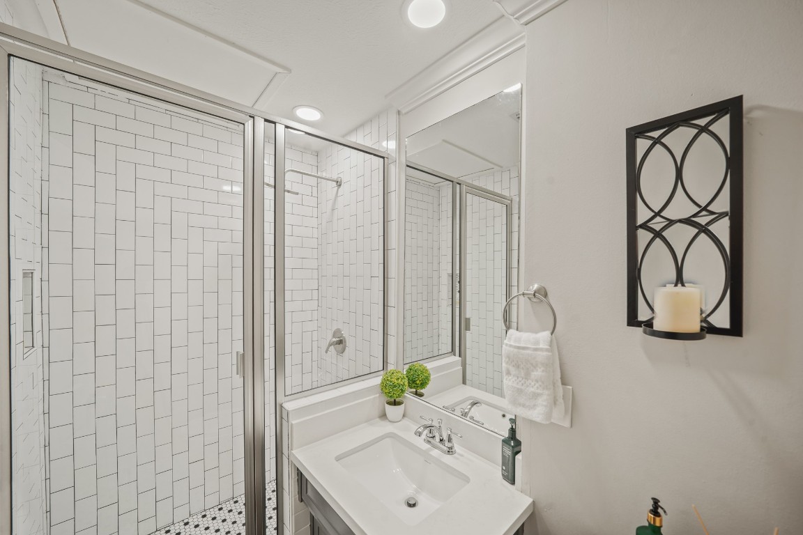 15831 Ridge Park Drive Houston, TX 77095 - Photo 17 of 26 This bathroom features a modern design with white subway tiles in a walk-in shower, a sleek vanity with a white countertop, and contemporary lighting.