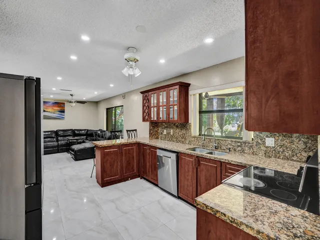 a kitchen with stainless steel appliances granite countertop a refrigerator stove and oven