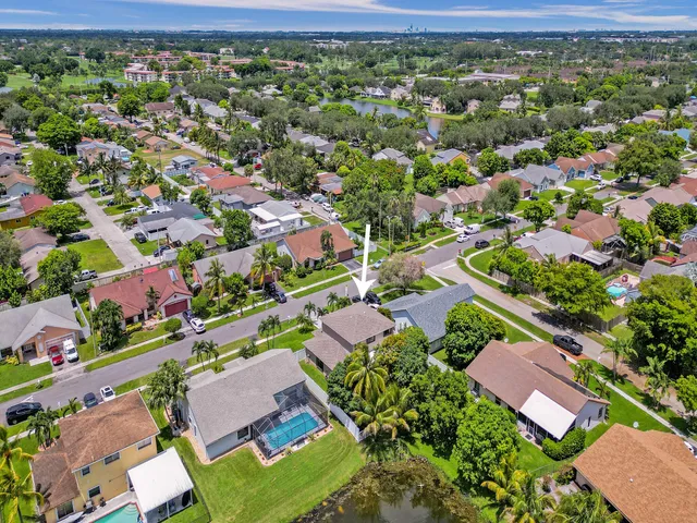 an aerial view of residential houses with outdoor space and trees