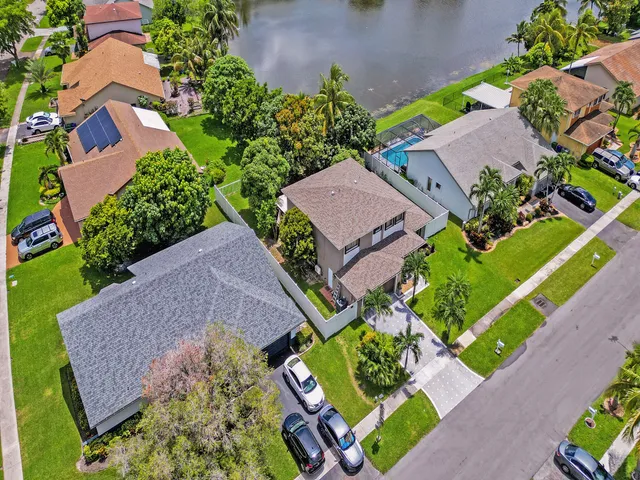 an aerial view of residential houses with outdoor space and street view