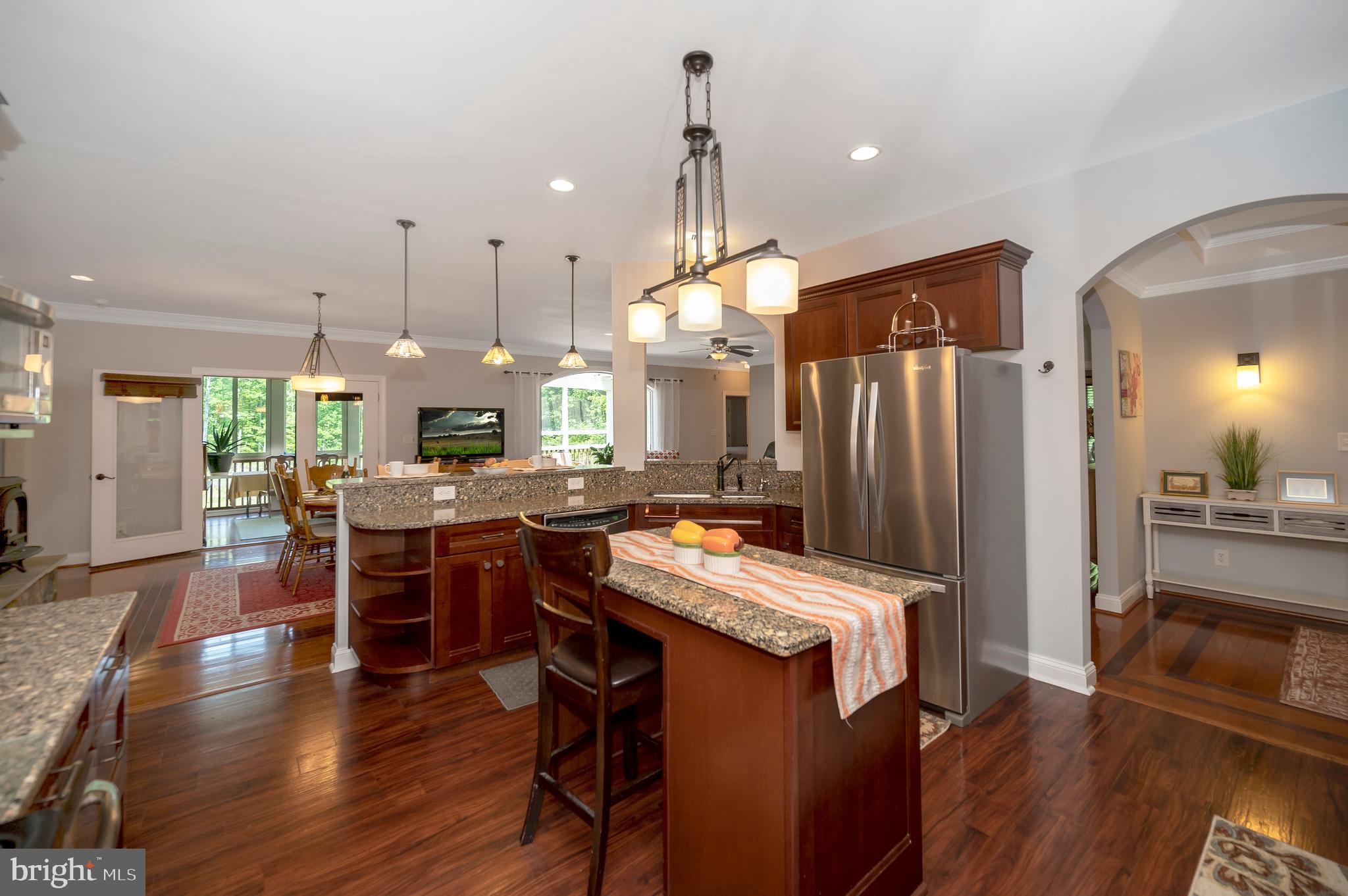 28229 Beech Drive Rhoadesville, VA 22542 - Photo 12 of 62 a kitchen with stainless steel appliances kitchen island granite countertop a table chairs and a refrigerator