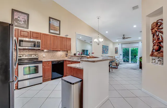 a kitchen with kitchen island granite countertop wooden cabinets and a stove