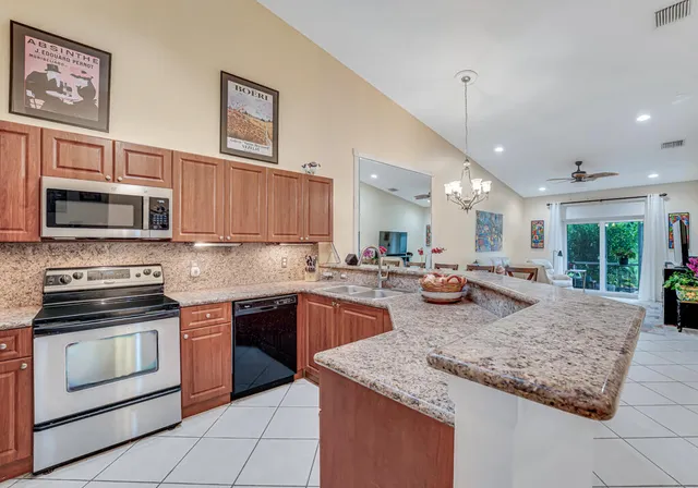 a kitchen with stainless steel appliances granite countertop wooden cabinets and a stove top oven