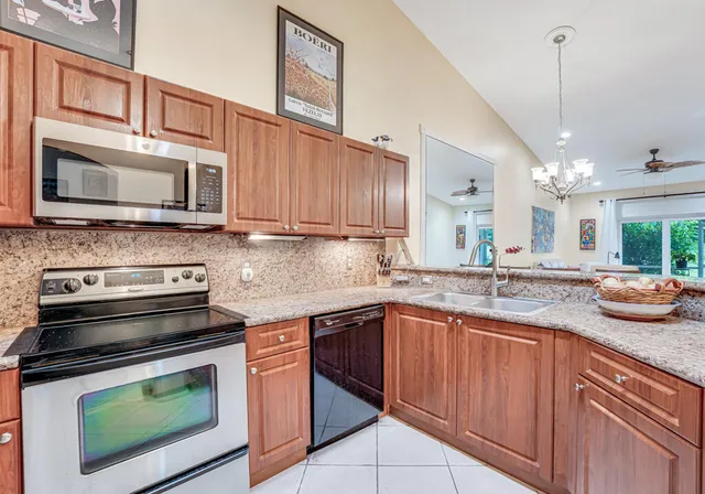 a kitchen with stainless steel appliances granite countertop a refrigerator stove and microwave