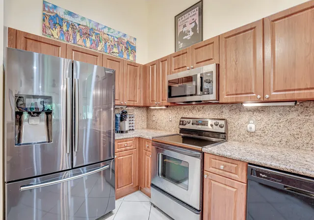 a kitchen with granite countertop stainless steel appliances a refrigerator and counter space