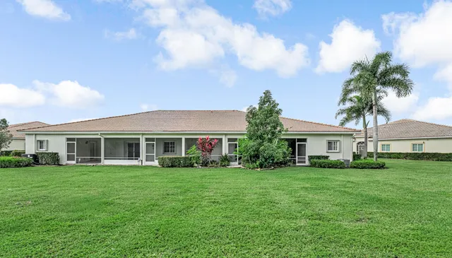 a front view of house and yard with beautiful flowers and green space