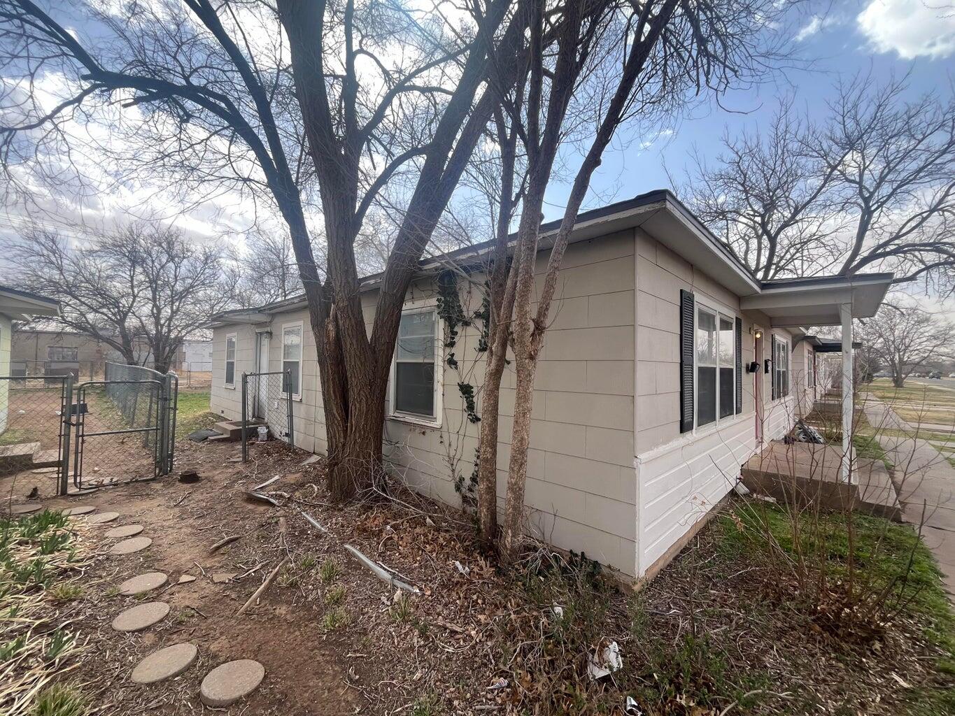 3113 33rd Street, Unit A Lubbock, TX 79410 - Photo 10 of 10 a white house that has a tree in front of it