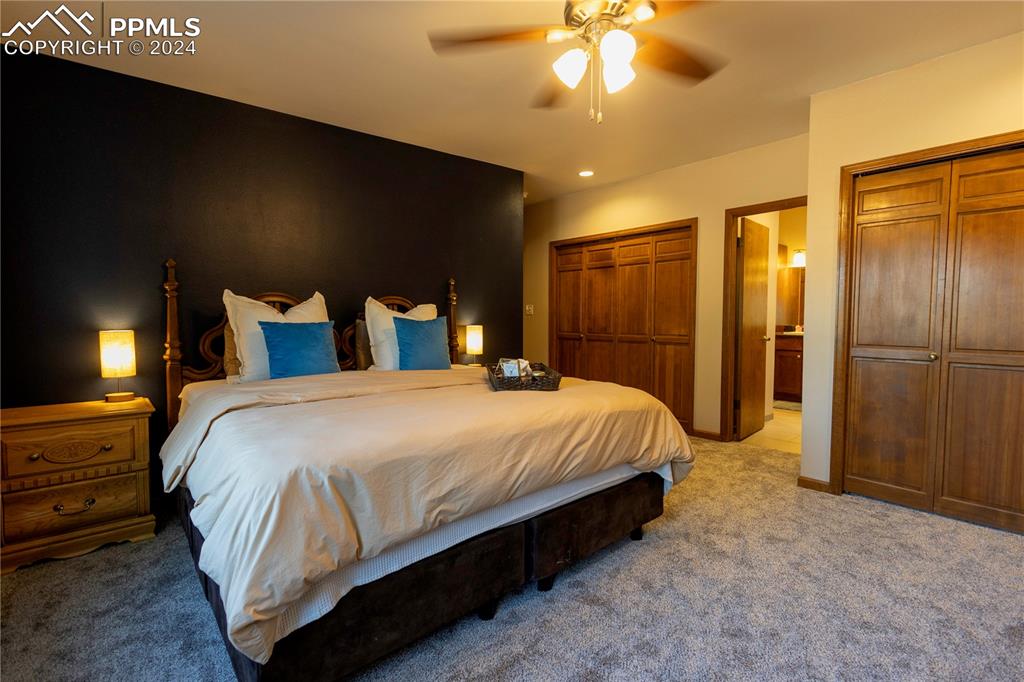 3123 Broadmoor Valley Road, Unit D Colorado Springs, CO 80906 - Photo 15 of 38 a bedroom with a bed and a chandelier