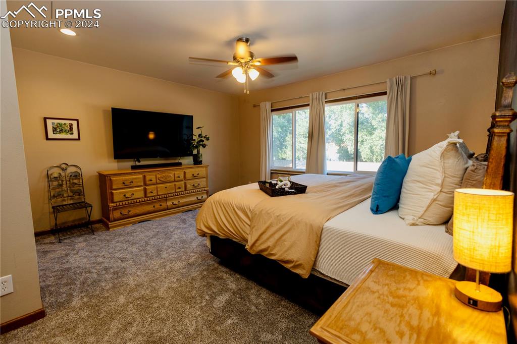 3123 Broadmoor Valley Road, Unit D Colorado Springs, CO 80906 - Photo 19 of 38 a bedroom with a bed and a flat screen tv