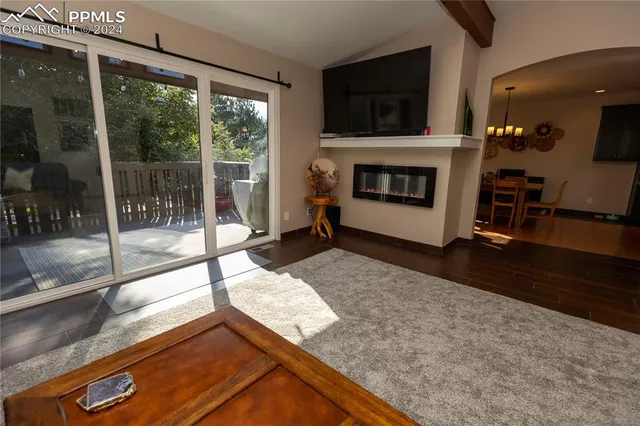 a living room with a large window and a fireplace