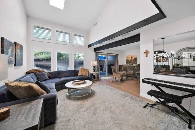 a living room with furniture a flat screen tv and a large window