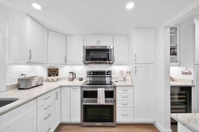 a large white kitchen with cabinets