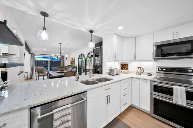 a kitchen with stainless steel appliances granite countertop a refrigerator and a stove top oven