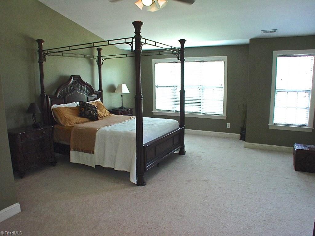 711 Number Ten Way Oak Ridge, NC 27310 - Photo 19 of 25 Plenty of space in the Master bedroom. Peaked ceiling adds to the open feeling in the room.
