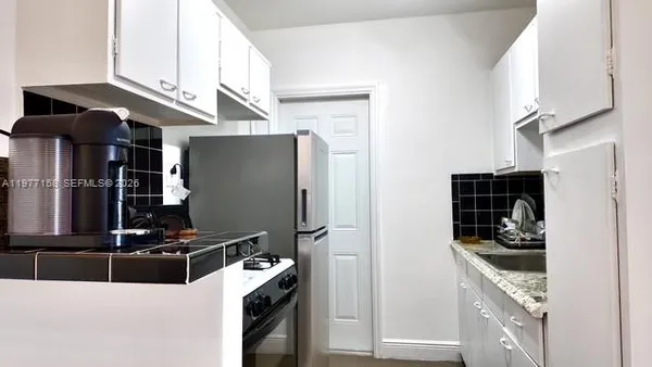 a kitchen with stainless steel appliances granite countertop a refrigerator and a stove