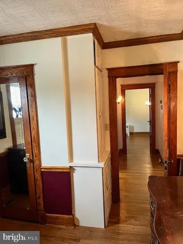 an empty room with wooden floor fireplace and windows