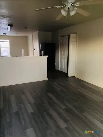 a view of a kitchen with wooden floor and a ceiling fan