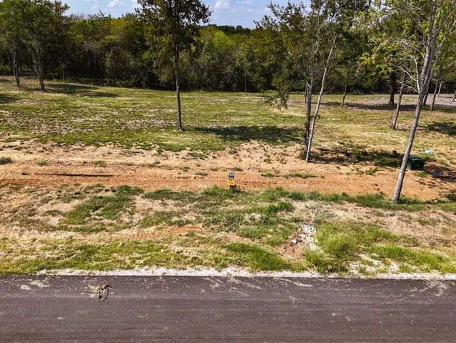 a view of a yard with wooden fence