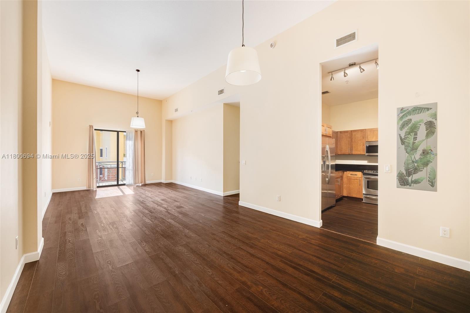 8395 Southwest 73rd Avenue, Unit 320 Miami, FL 33143 - Photo 4 of 18 a view of a kitchen with wooden floor and an empty room
