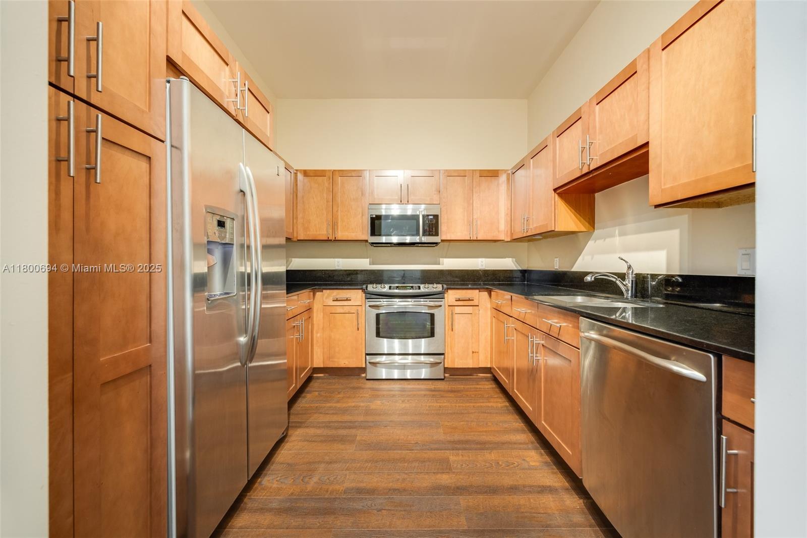 8395 Southwest 73rd Avenue, Unit 320 Miami, FL 33143 - Photo 6 of 18 a large kitchen with stainless steel appliances granite countertop a stove a sink and a refrigerator