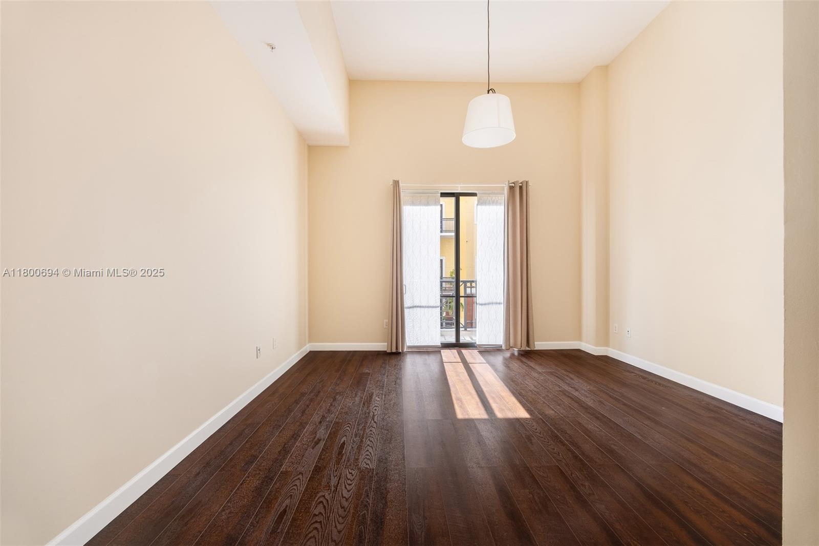 8395 Southwest 73rd Avenue, Unit 320 Miami, FL 33143 - Photo 9 of 18 a view of an empty room with wooden floor and a window