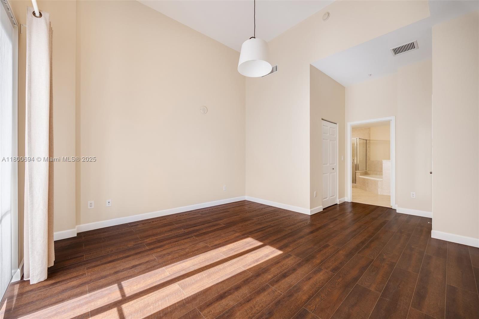 8395 Southwest 73rd Avenue, Unit 320 Miami, FL 33143 - Photo 10 of 18 a view of an empty room with wooden floor and a window