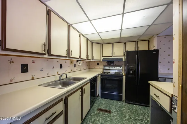 a kitchen with a sink a refrigerator and cabinets