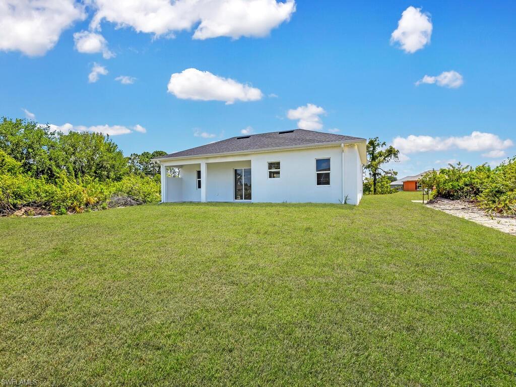6006 Stratton Road Fort Myers, FL 33905 - Photo 6 of 27 Rear view of property featuring a lawn