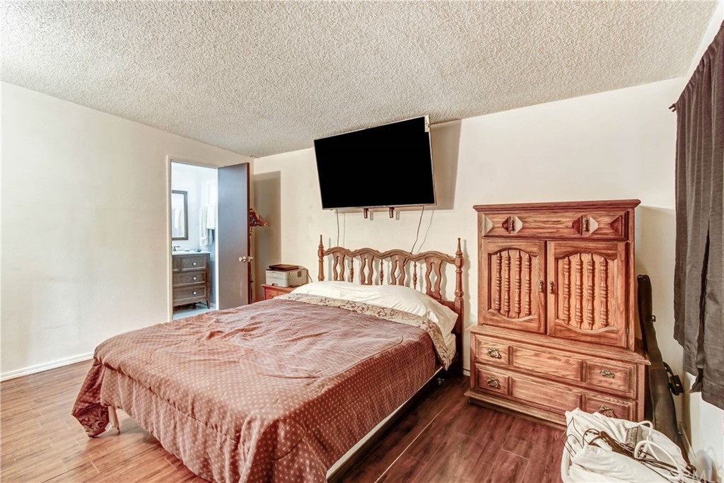 61495 La Jolla Drive Joshua Tree, CA 92252 - Photo 16 of 21 a bedroom with a bed a flat screen tv and a couch