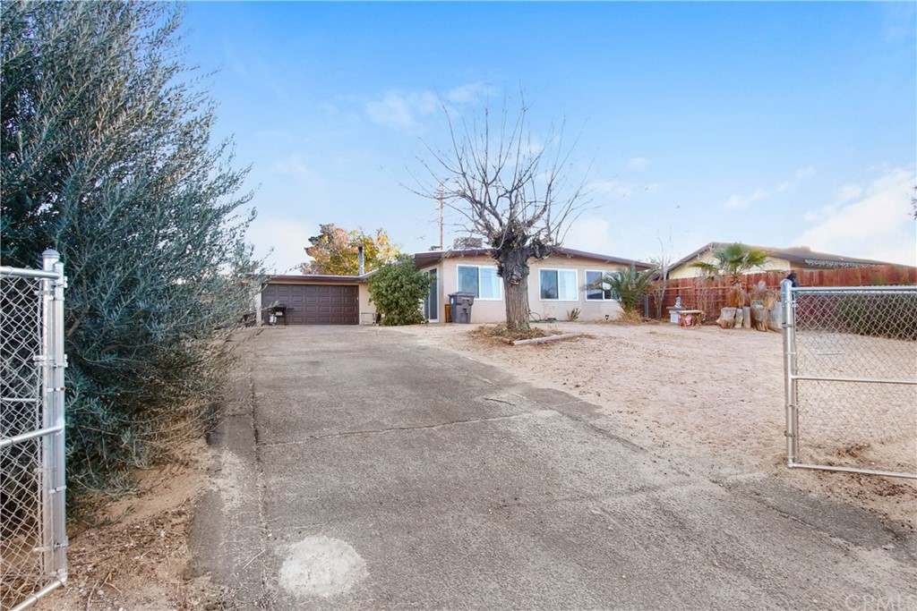 61495 La Jolla Drive Joshua Tree, CA 92252 - Photo 3 of 21 a front view of a house with a yard and garage