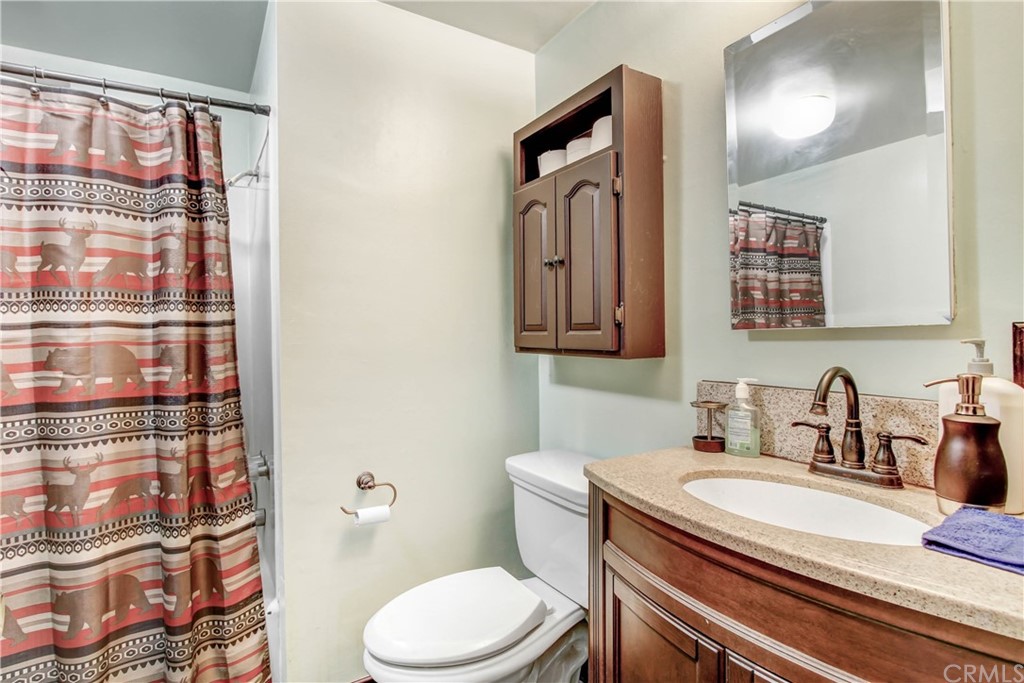 61495 La Jolla Drive Joshua Tree, CA 92252 - Photo 10 of 21 a bathroom with a sink a toilet and shower curtain