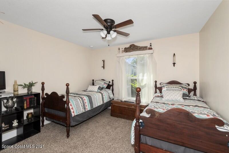1808 Holbrook Road Northwest Palm Bay, FL 32907 - Photo 11 of 28 a bedroom with a bed and ceiling fan