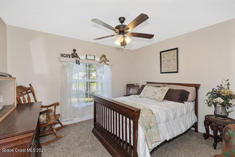 1808 Holbrook Road Northwest Palm Bay, FL 32907 - Photo 13 of 28 a bedroom with a bed and a chandelier