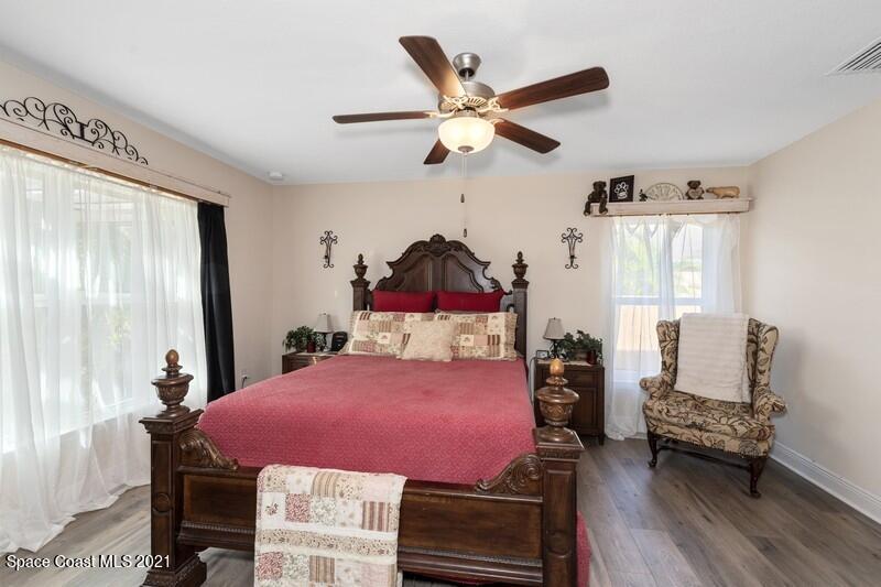 1808 Holbrook Road Northwest Palm Bay, FL 32907 - Photo 8 of 28 a bedroom with a bed a chandelier and a window
