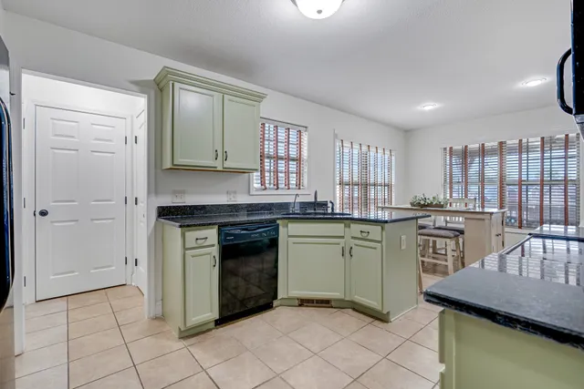 a kitchen with kitchen island granite countertop a stove sink and cabinets