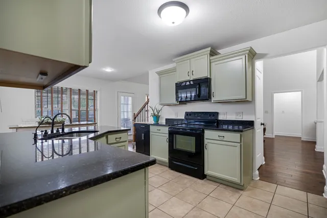 a kitchen with stainless steel appliances granite countertop a stove a sink and a microwave