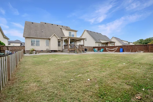 a view of a house with a big yard and large trees