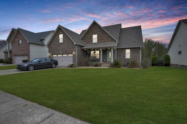 a front view of a house with a garden and yard