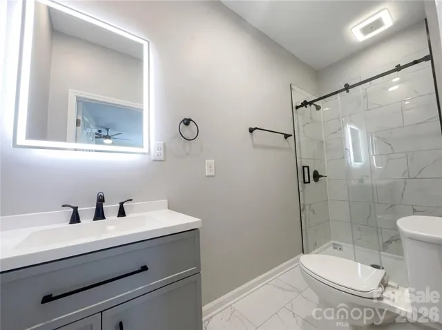 a bathroom with a sink a toilet and shower