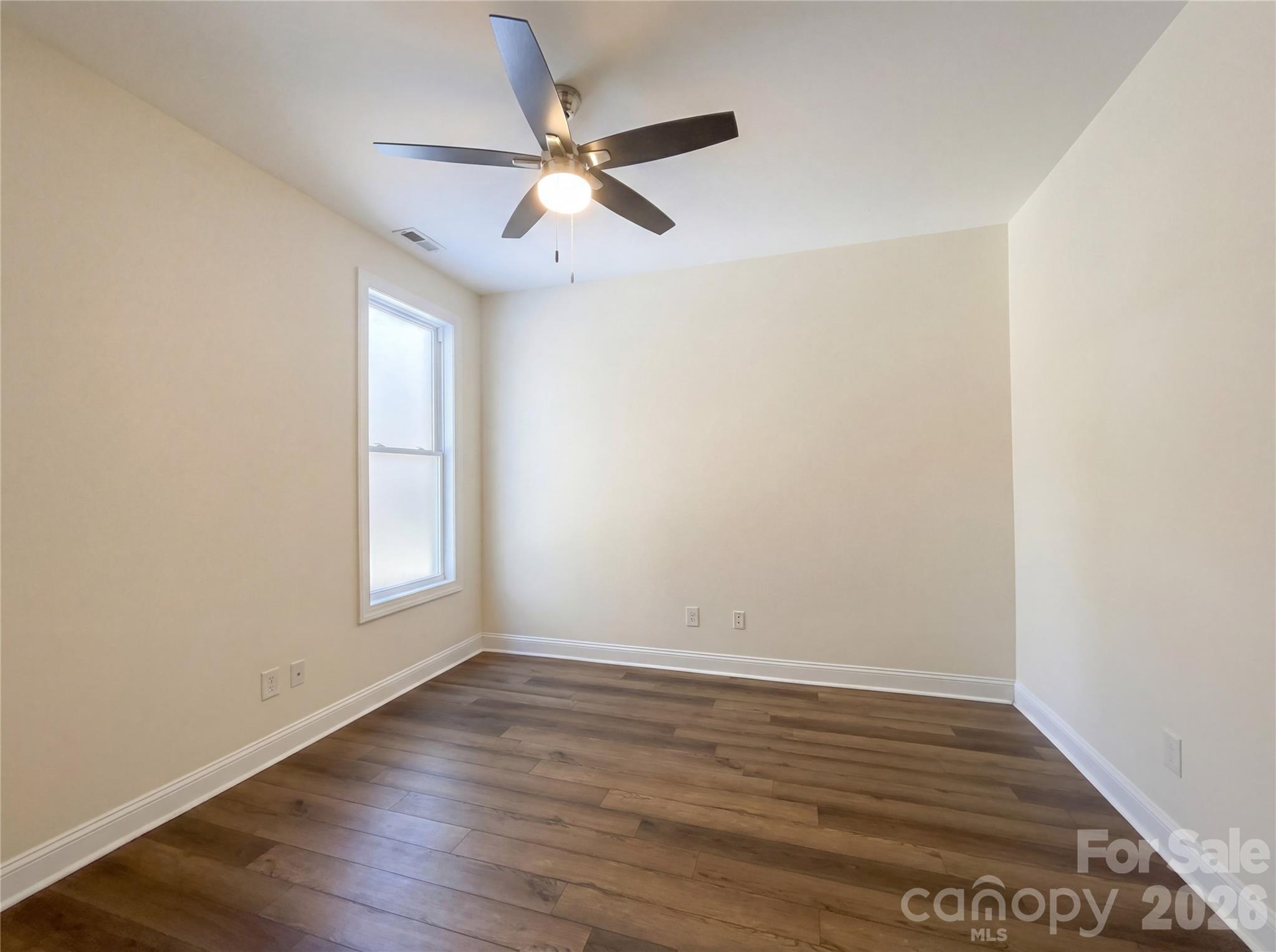 405 Isle Of Pines Road Mooresville, NC 28117 - Photo 15 of 18 an empty room with wooden floor fan and windows